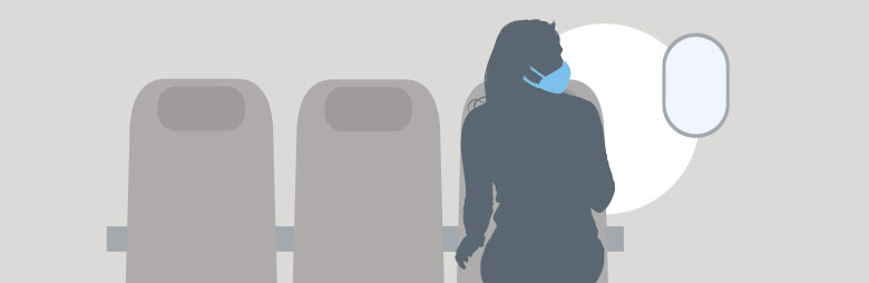 A passenger wearing their mask on the airplane and observing physical distancing to help them stay healthy while flying.